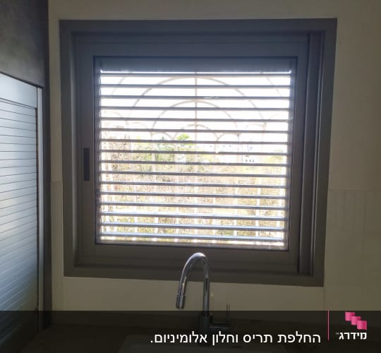 חלון עם תריסים מעל כיור במטבח